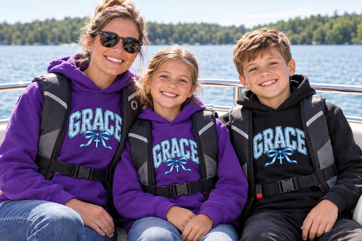Mother, daughter and son wearing GRACE hoodies and life jackets on a boat ride