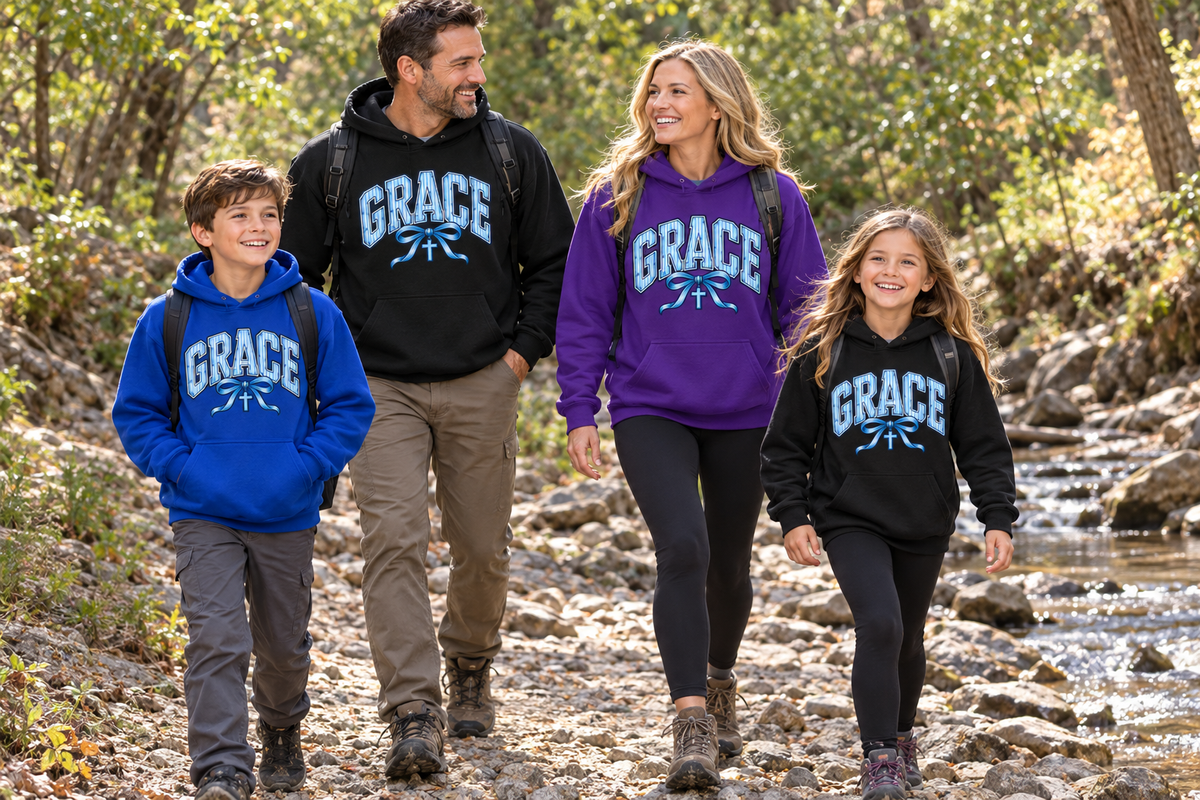 Mother, father, son and daughter wearing GRACE hoodies hiking beside a woodland creek